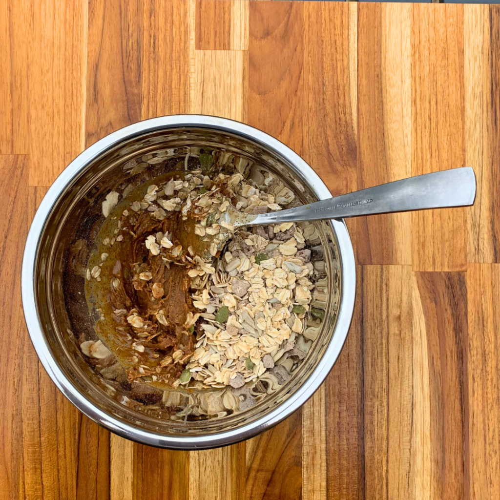 A mixing bowl containing ZEGO Cinnamon Twist Muesli and other ingredients for Gluten Free Gingerbread Cookie Energy Balls